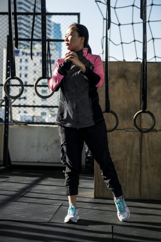 A woman doing exercise at the fitness gym to wear a cargo pants. She is ready for exercise but her attention is another way.